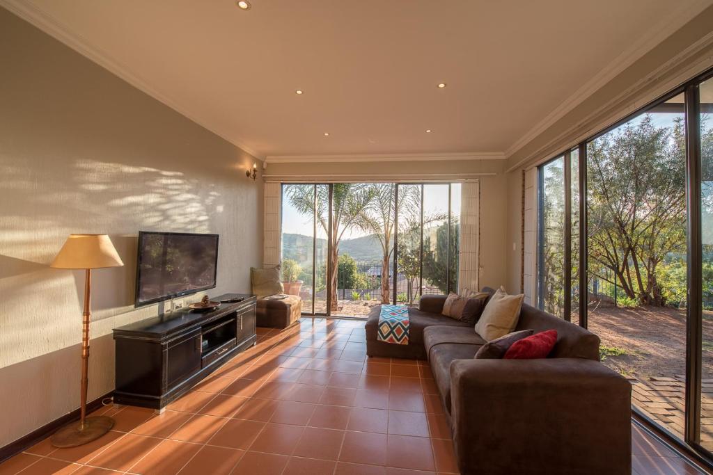 un soggiorno con divano e TV a schermo piatto di Map's View Guesthouse a Johannesburg
