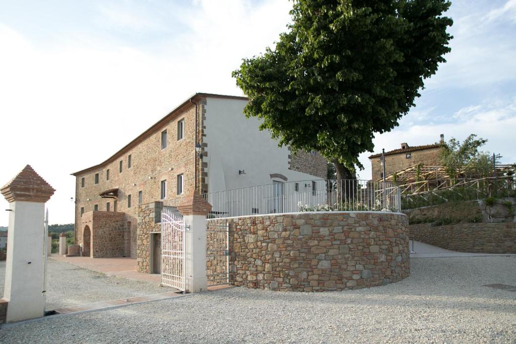 un edificio de ladrillo con una puerta y una pared de piedra en La Dispensa-bio agriturismo en Lamporecchio