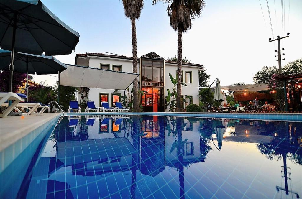- une piscine avec des chaises et un parasol dans l'établissement Kilim Hotel, à Dalyan