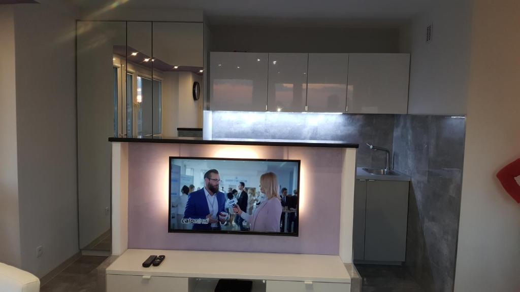 Televízia a/alebo spoločenská miestnosť v ubytovaní Centre Apartamenty Warszawa