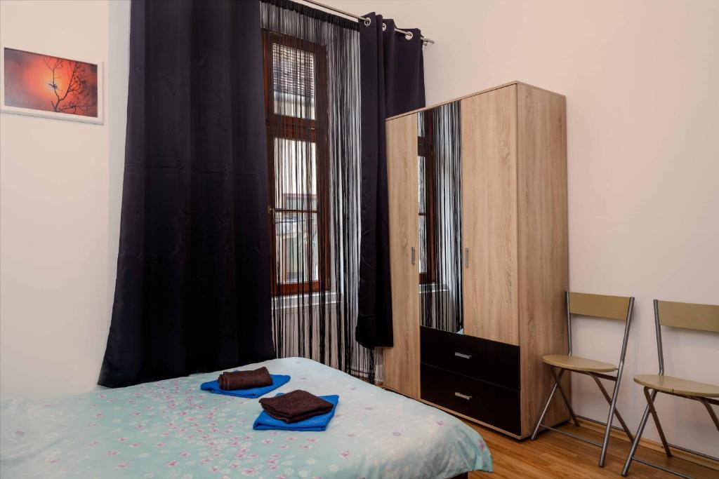 1 dormitorio con 1 cama y armario de madera en M Central Apartments, en Cluj-Napoca