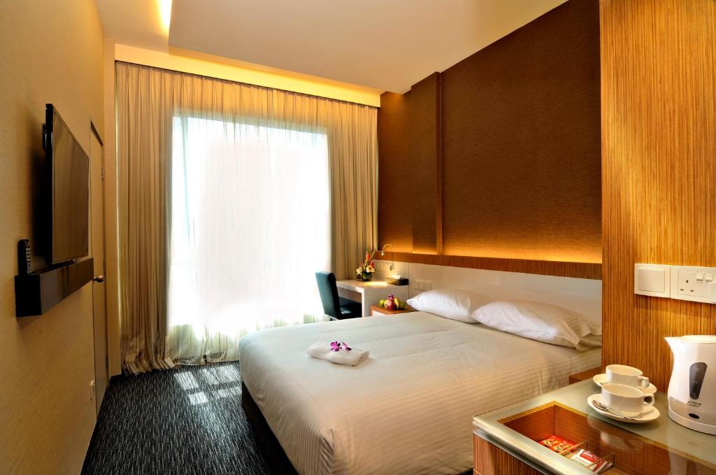 Habitación de hotel con cama y ventana en The Seacare Hotel en Singapur