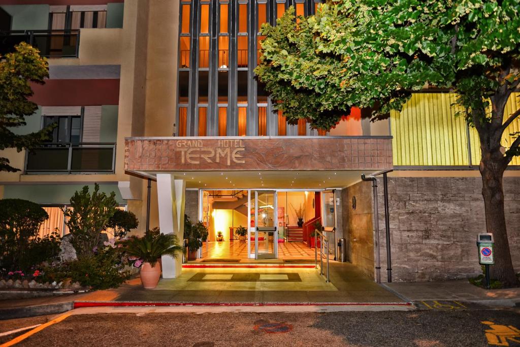 une entrée dans un bâtiment avec un panneau indiquant l'évolution dans l'établissement Grand Hotel Delle Terme, à Terme Luigiane