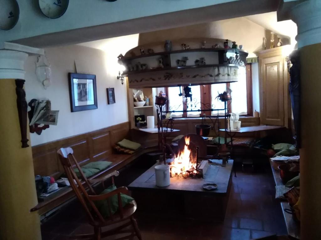 a living room with a fireplace in the middle of a room at Sot la Cleva in Socchieve