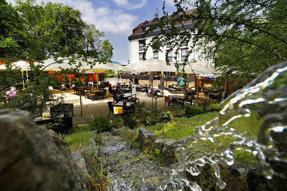 un jardin avec des tables et des chaises en face d'un bâtiment dans l'établissement Hotel Estricher Hof, à Trèves