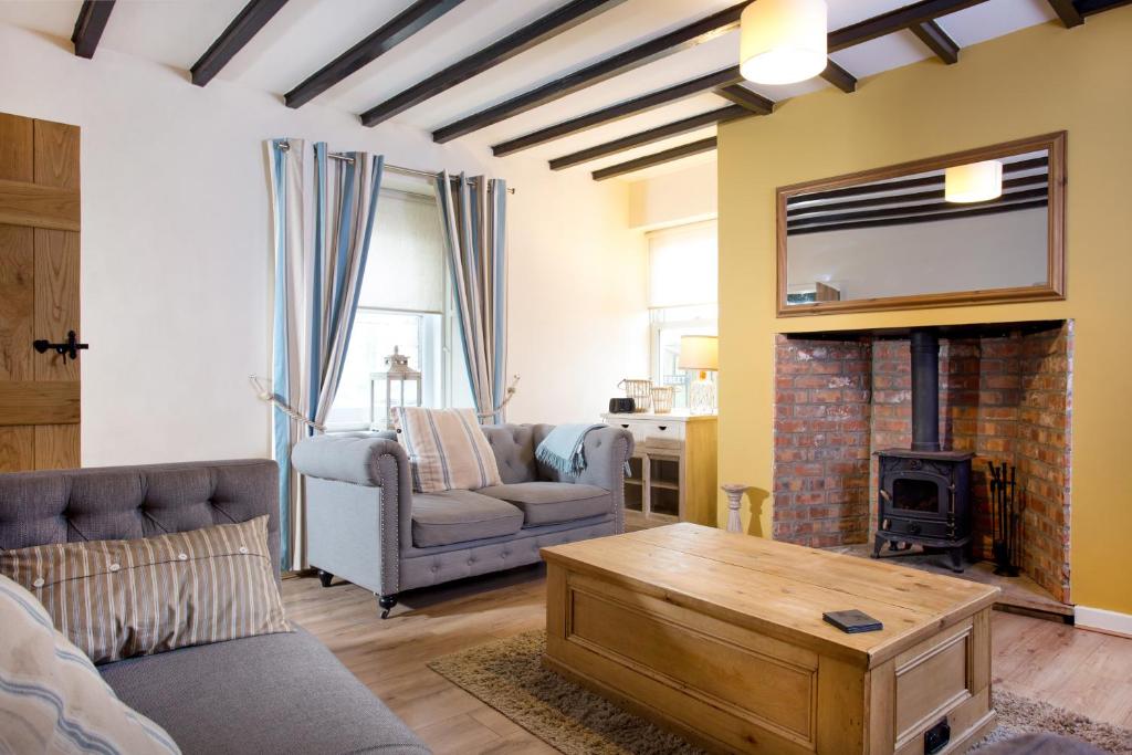 a living room with a couch and a fireplace at Hexham Cottage in Seahouses