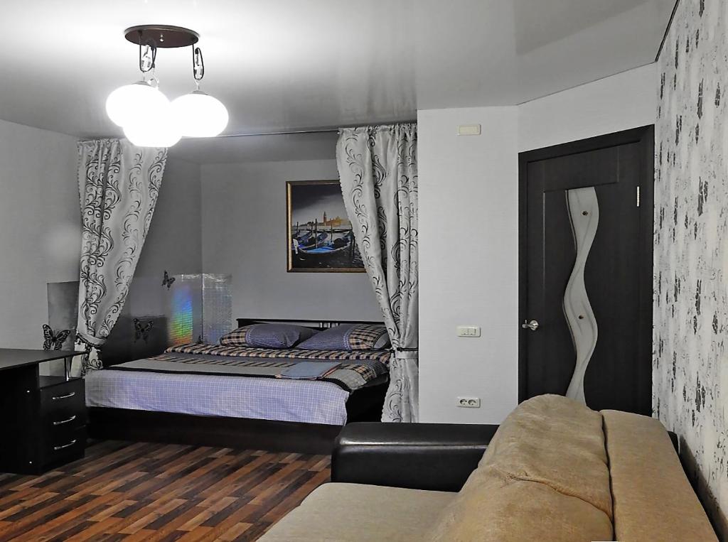チェレポヴェツにあるAjiekc Apartmentのベッドルーム(ベッド1台、ソファ付)