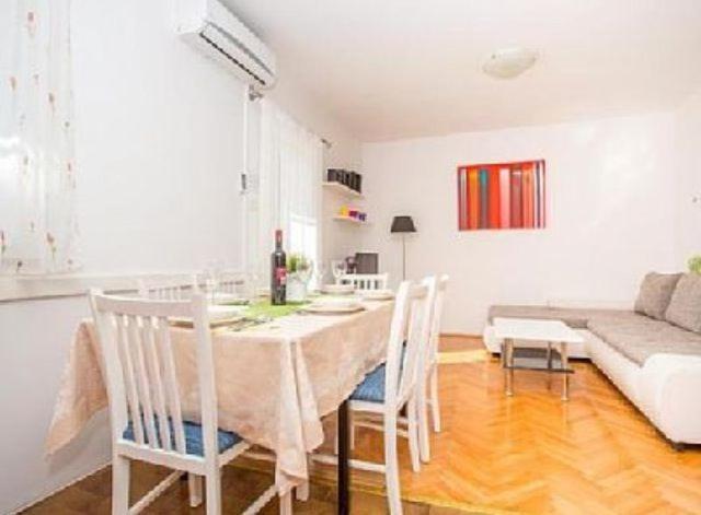 a living room with a table and chairs and a couch at Apartman Makarska in Makarska