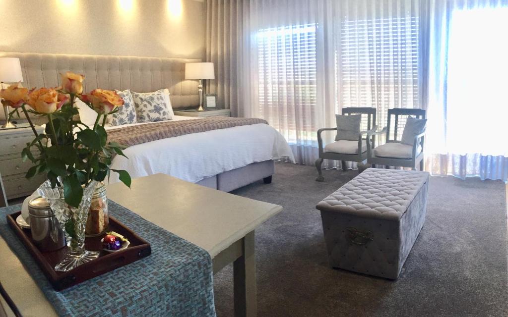 a hotel room with a bed and a table with flowers at Se La Vie Guest Suite in Big Bay