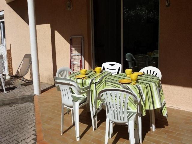 einem Tisch mit Stühlen und einem grünen und weißen Tischtuch in der Unterkunft 4SAP7 Appartement avec belle terrasse in Collioure