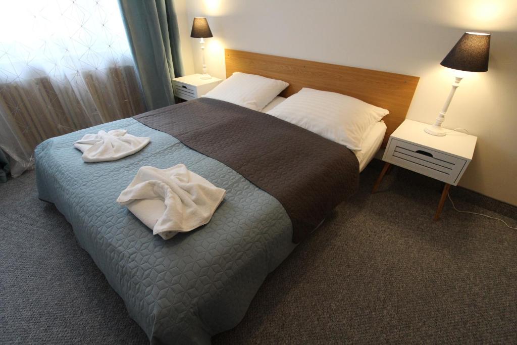 a hotel room with a bed with two towels on it at Słoneczny apartament przy promenadzie in Świnoujście