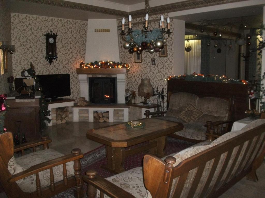 sala de estar con sofá, mesa y chimenea en Hotel Rittinger en Bonyhád