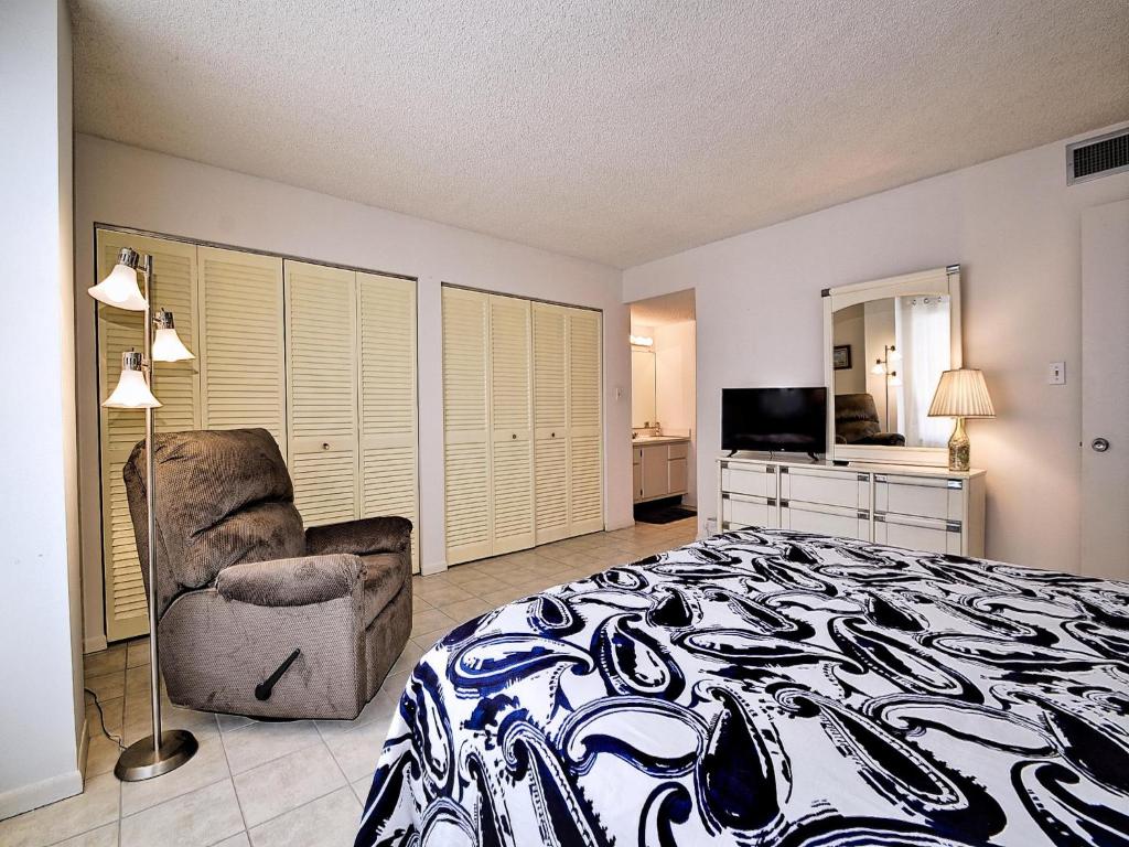 a bedroom with a bed and a chair and a television at 440 West Condo 1604N in Clearwater Beach