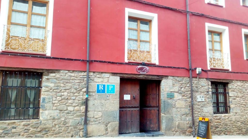a red building with two doors and windows at Posada Santa Rita in Enciso