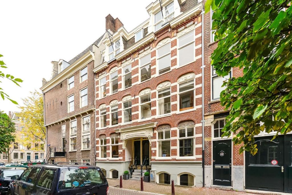 アムステルダムにあるAmsterdam Appartment in the centre of Amsterdamの大きなレンガ造りの建物の前に停められた車