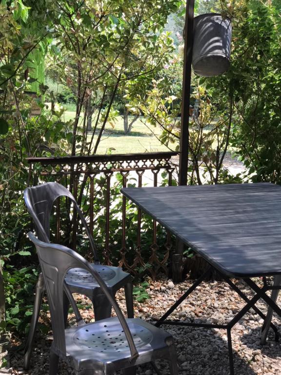 a table and a chair next to a table and a lamp at Gîte du domaine de la Manse in Villeneuve-de-Berg