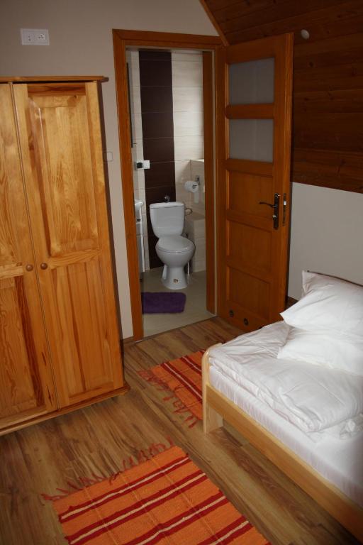 a bedroom with a bed and a bathroom with a toilet at Zawojska Przystań in Zawoja