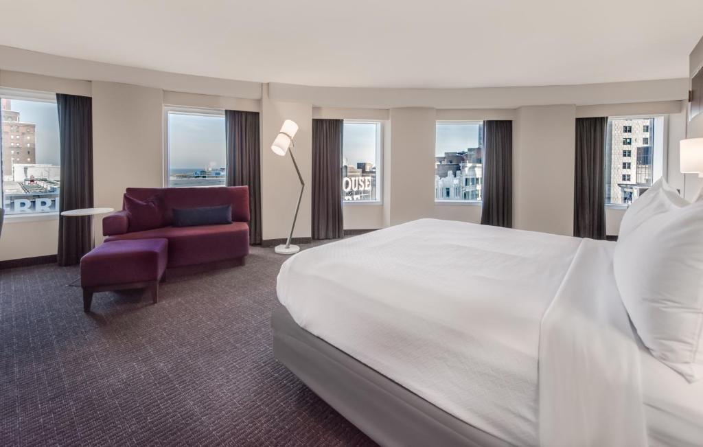 ein Hotelzimmer mit einem Bett, einem Stuhl und Fenstern in der Unterkunft Crowne Plaza Cleveland at Playhouse Square, an IHG Hotel in Cleveland