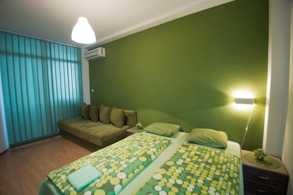 een woonkamer met twee bedden en een bank bij Sweet Apartments or Rooms in Niš