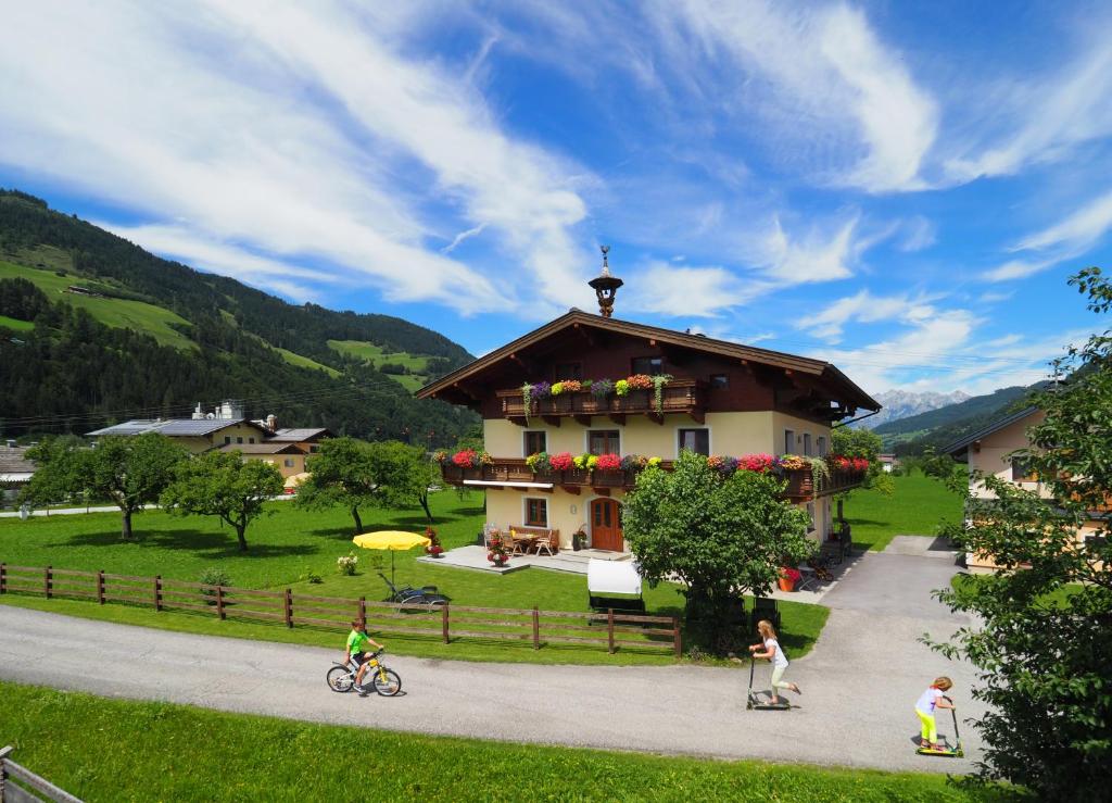a group of people riding bikes and a house at Bio-Bauernhof Reiterhof in Sankt Johann im Pongau