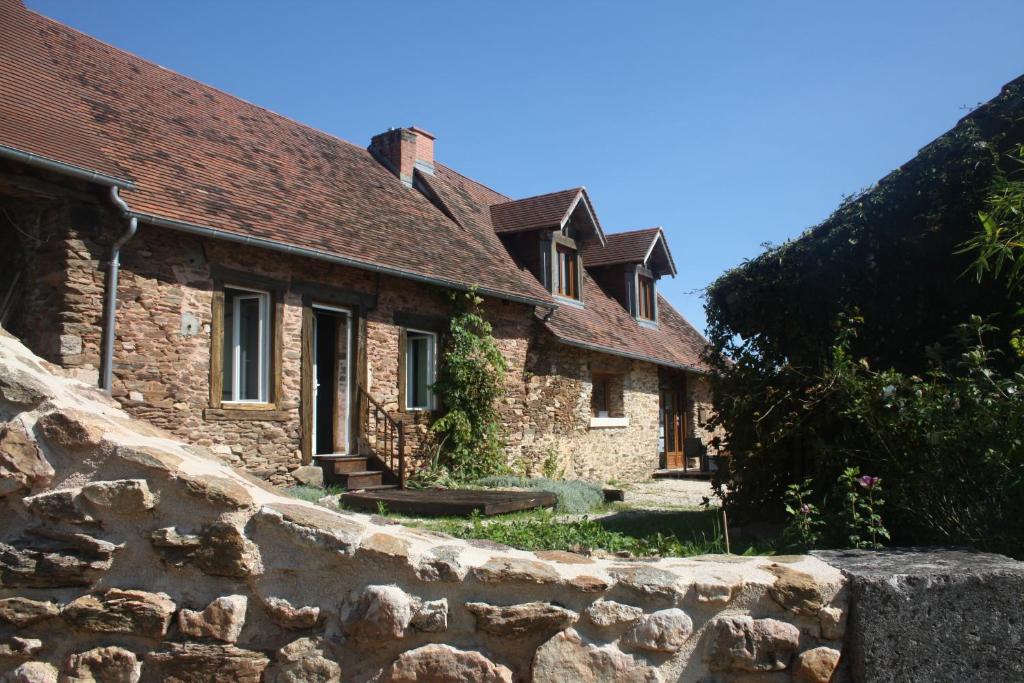 une ancienne maison en pierre avec un mur en pierre dans l'établissement B&B Le Relais de Chantecor, à La Coquille