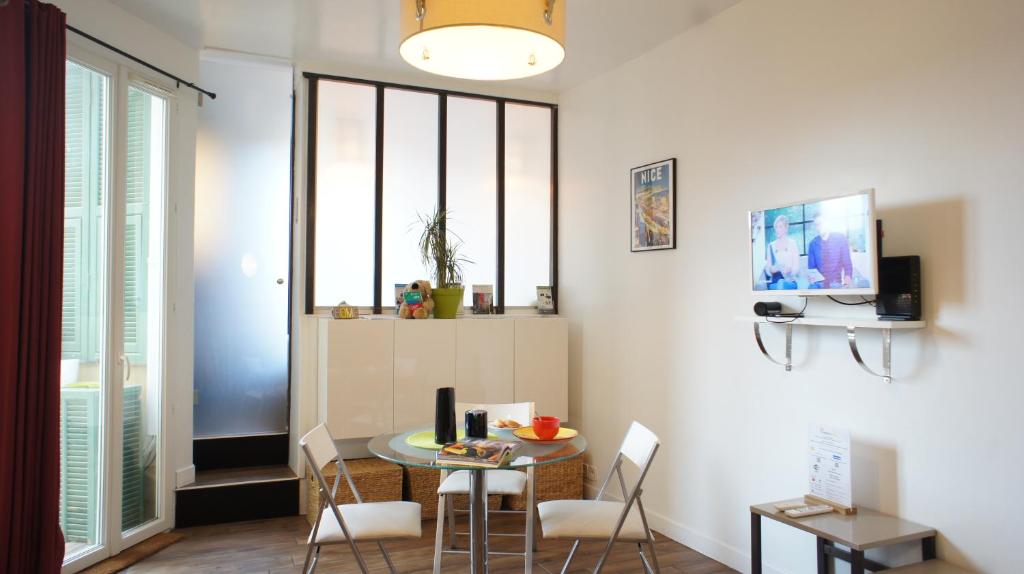 - un salon avec une table, des chaises et une télévision dans l'établissement Ze Perfect Place - Ideal ! 2 Pièces Antiquaires, Port Garibaldi, à Nice