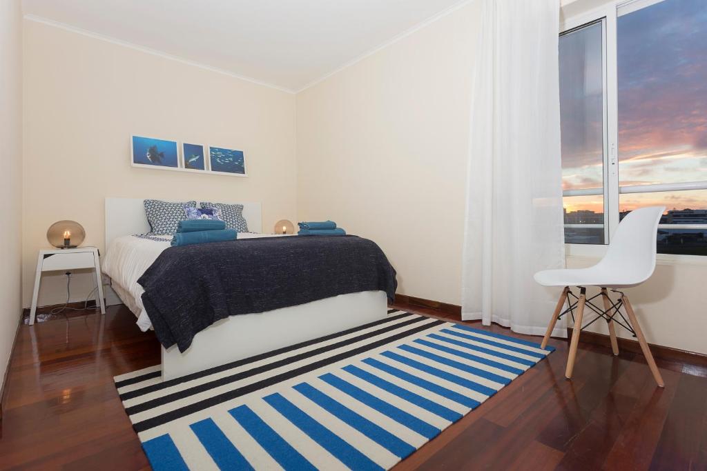 Schlafzimmer mit einem Bett mit einem blauen und weißen Teppich in der Unterkunft Green & Blue 3 Bedrooms in Ponta Delgada