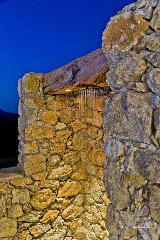 an old stone wall at night with a rock at Lux View Villas in Kyra Panagia