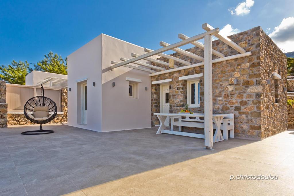 a white house with a wooden pergola on a patio at Lux View Villas in Kyra Panagia