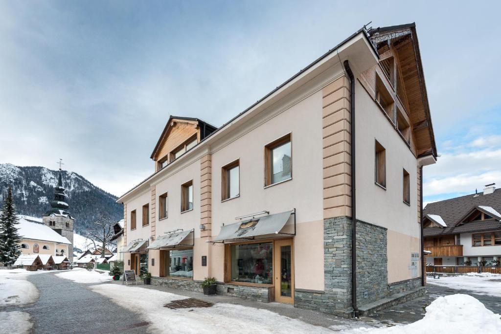 a building on a street with snow on the ground at Apartments Budinek in Kranjska Gora
