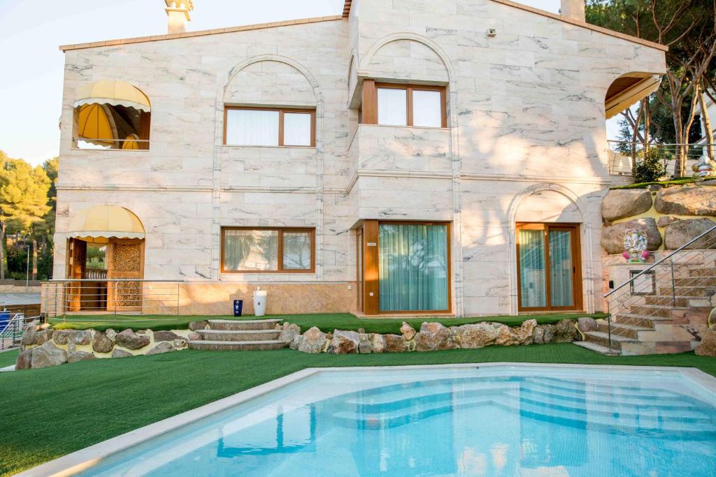 uma casa com uma piscina em frente em Eco Geo Sol em Lloret de Mar