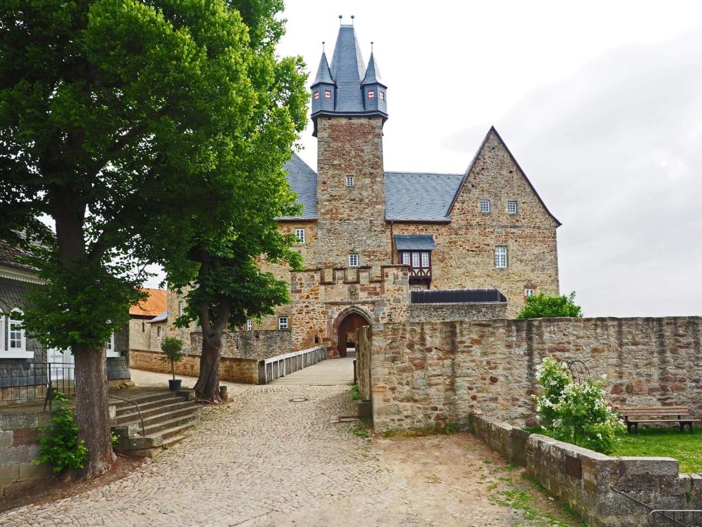 un antico edificio in pietra con torre dell'orologio di Schloss Spangenberg a Spangenberg