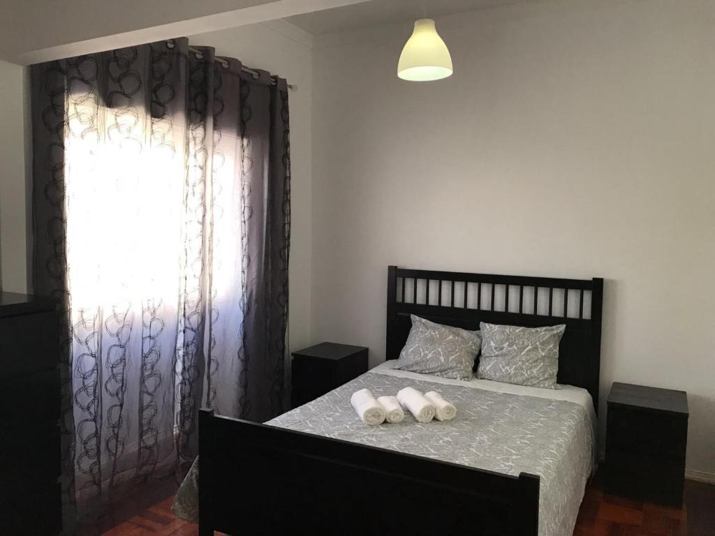 a bedroom with a bed with two pillows and a window at Apartamento Lisboa-Alameda in Lisbon