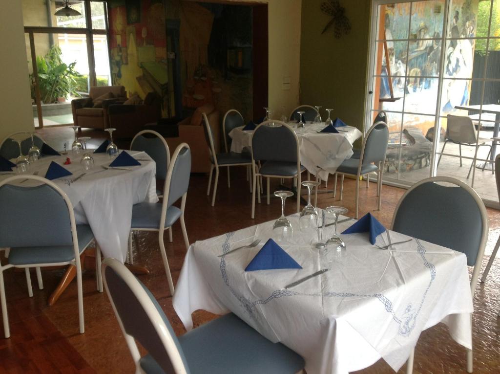 a room with tables and chairs with blue napkins on them at Grampians Motel /Hotel in Dadswells Bridge