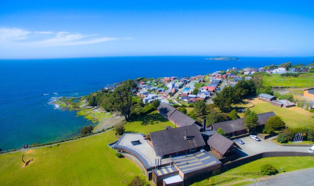 an aerial view of a house next to the ocean at Panamericana Hotel Ancud in Ancud