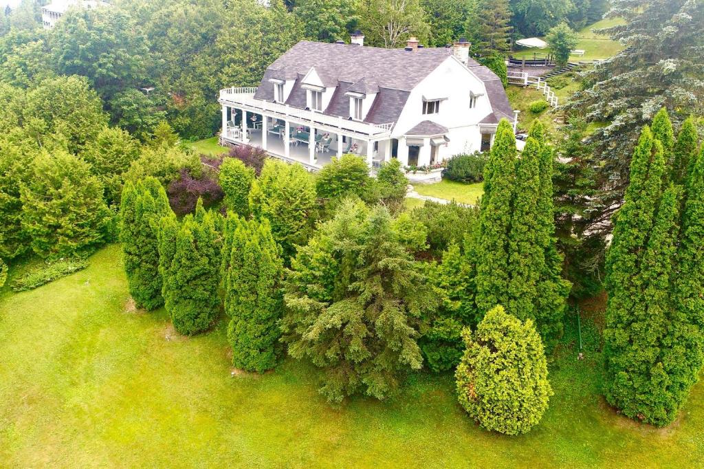 una vista aérea de una gran casa blanca con árboles en 241 - La Côte Fleurie - Les Immeubles Charlevoix en La Malbaie