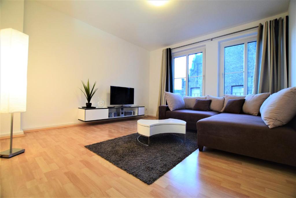 a living room with a couch and a tv at Old Town 2 Room Apartments in Düsseldorf