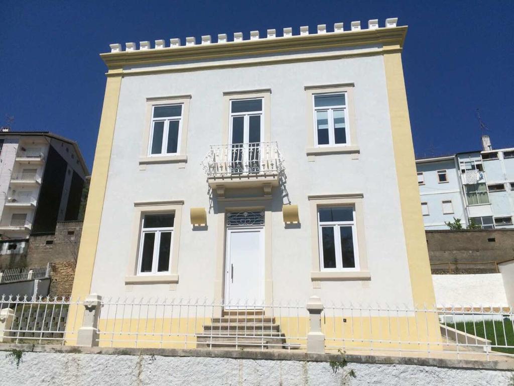 ein großes weißes Gebäude mit Balkon in der Unterkunft CoimbraAmeias in Coimbra