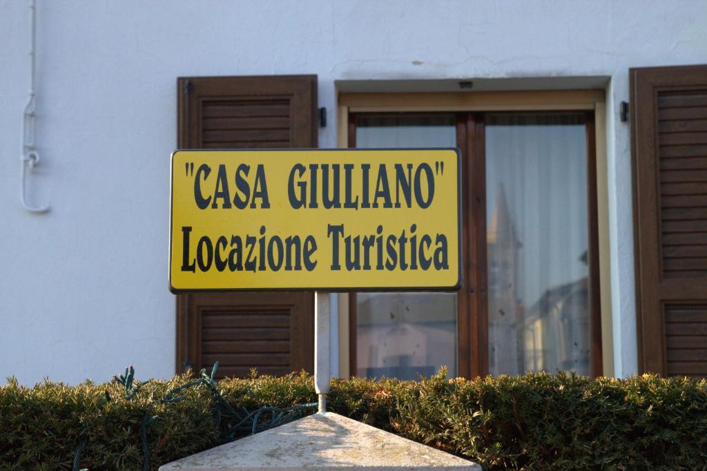 una señal de calle amarilla frente a un edificio en Casa Giuliano en Pincara