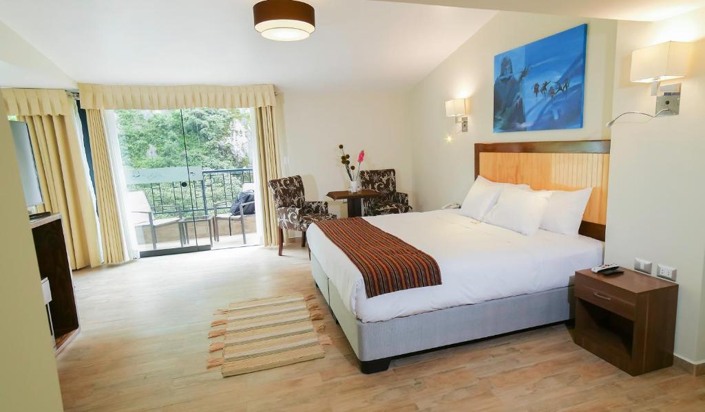 マチュピチュにあるGolden Sunrise Machupicchuのベッドとバルコニー付きのホテルルーム