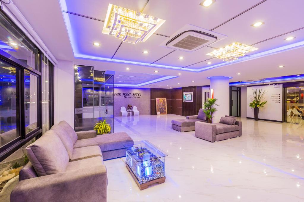 a lobby with couches and a table in a building at River Front Krabi Hotel in Krabi