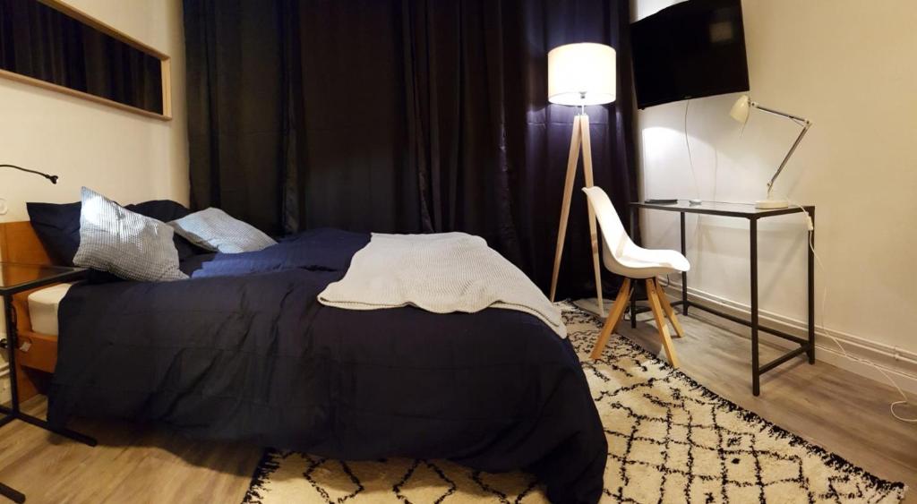une chambre avec un lit, une table et une lampe dans l'établissement Cozy studio Metz, à Metz
