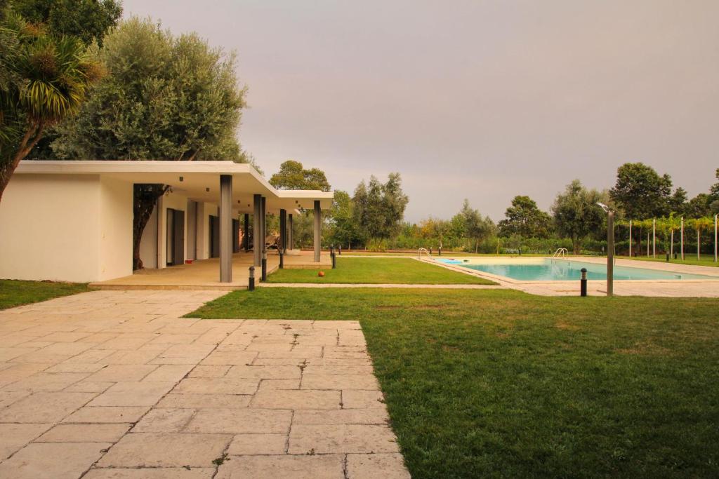 a park with a building and a swimming pool at ARTS IN Country House in Tondela