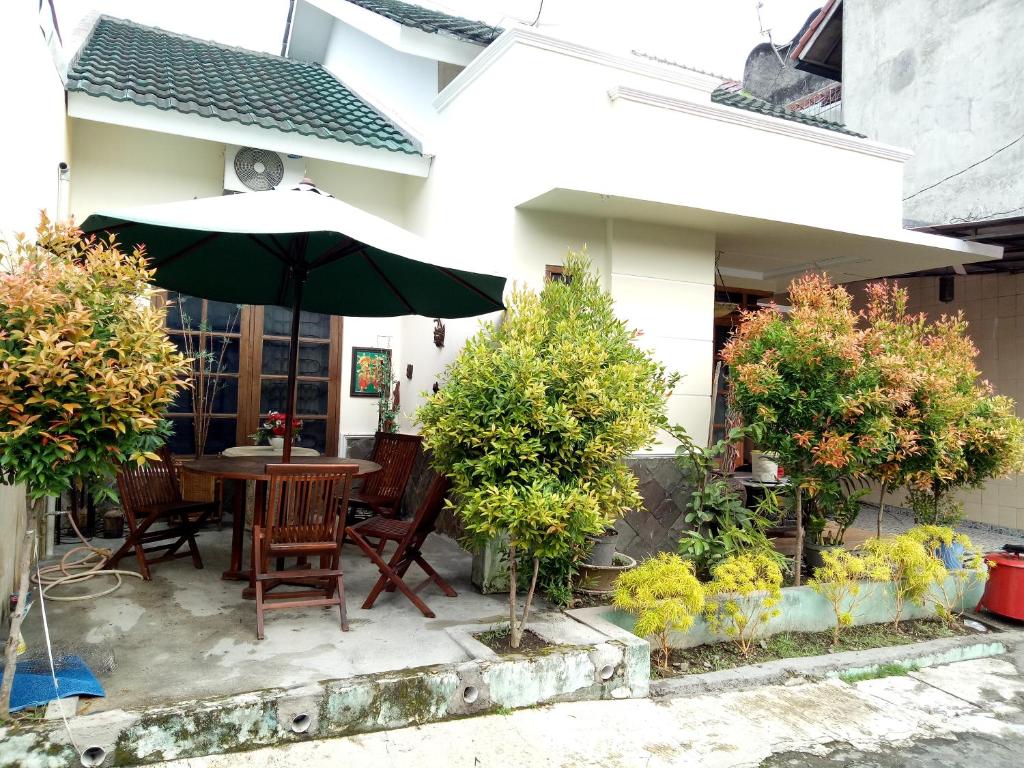 a patio with a table with an umbrella at Guest House Abimanyu in Kaliurang