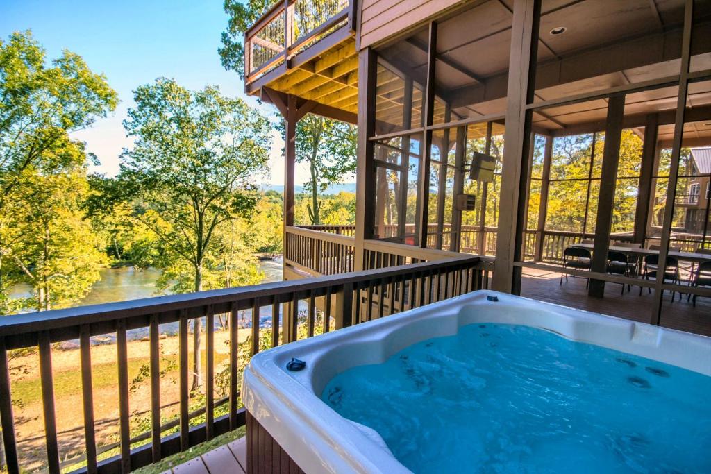 a hot tub on the balcony of a house at Eagle's Nest- A pet friendly cabin on the river! in Luray
