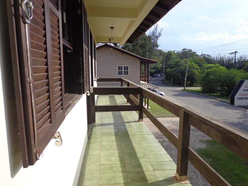 balcón de una casa con barandilla de madera en Apartamento Sul na Praia da Ferrugem, en Garopaba