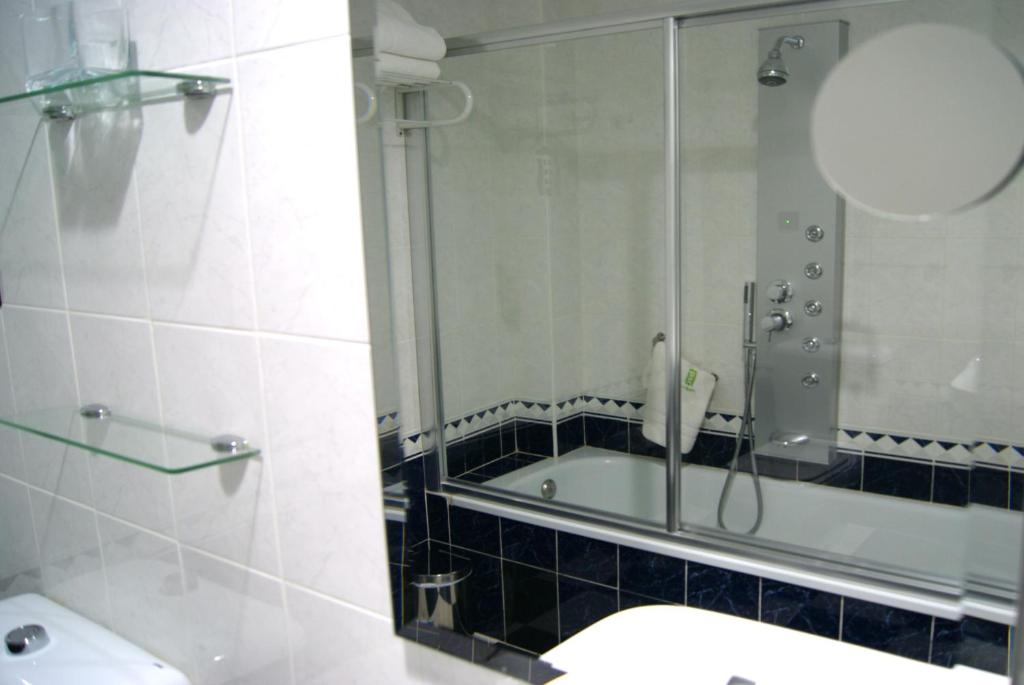 a bathroom with a shower and a tub and a sink at Hotel Molinos in Granada