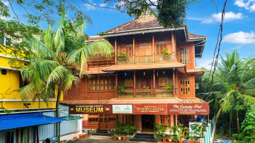 a tall wooden building with a store front at Kumarakom Wood Castle Serviced Appartments in Kumarakom