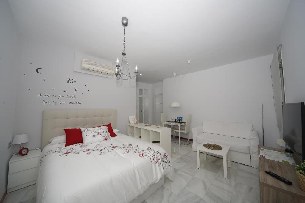 セビリアにあるLas llaves de San Pedroの白いベッドルーム(ベッド1台、椅子付)