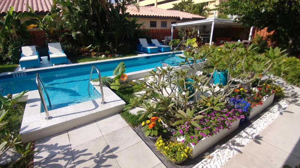 uma piscina com um jardim de flores ao lado em Downtown Hollywood Boutique Hotel em Hollywood